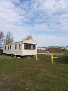 a mobile home sitting in a field of grass at Arizona Caravan in Camber
