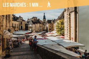 an image of a market with umbrellas and buildings at Studio proche centre ville in Sarlat-la-Canéda