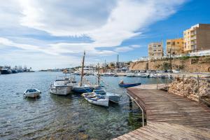un grupo de barcos atracados en el agua cerca de un muelle en Apartamento Sf2, en L'Ametlla de Mar