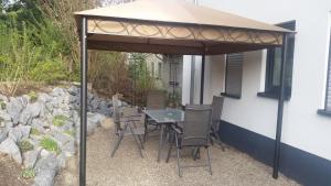 a table and chairs under an umbrella on a patio at Ferienwohnung Viva la Vida in Bendorf