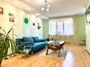 a living room with a blue couch and a table at Apartments in the city centre with a coffee machine, near a park in Rivne