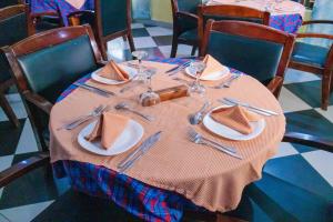 a table with plates and utensils on it at Durban Hotel in Dar es Salaam