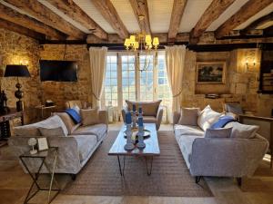 a living room with couches and a table at Château La Carrière in Saint-Cyprien