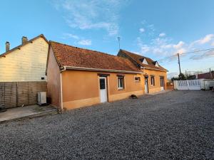 a house with a gravel driveway in front of it at Les Poissons Rouges in Lanchères