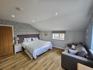 una camera da letto con un letto e un divano di Bramley Suite - The Apple Barn a Pettistree