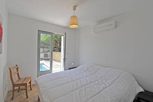 a bedroom with a bed and a chair and a window at Villa Doce Lar in Lioux +79 photos