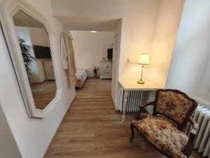 a hallway with a chair and a mirror at Etela Old Town Apartment in Košice
