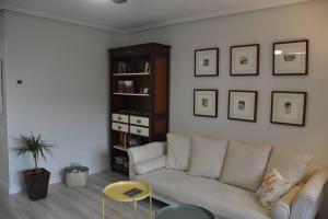 a living room with a white couch and a shelf at Apto La Estambrera I I Wifi y Aire Acondicionado in Logroño