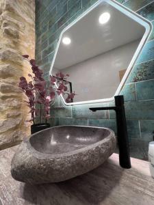 a bathroom with a stone sink and a mirror at URBAN Premium Jacuzzi estudio céntrico in Alicante +24 photos
