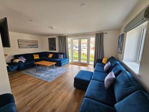 un soggiorno con un divano blu e un tavolo di Bramley Suite - The Apple Barn a Pettistree