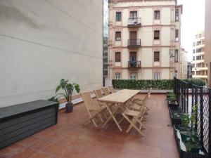 a patio with a wooden table and chairs on a balcony at GRAN BILBAO I in Barakaldo