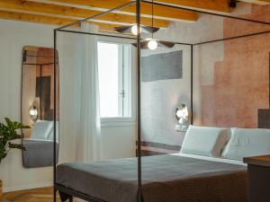 a bedroom with a canopy bed and a window at BRE Apartments - Aedes in Vicenza