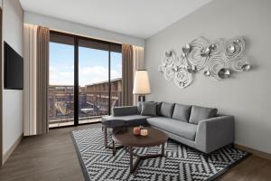 a living room with a couch and a large window at Courtyard by Marriott Bangkok Suvarnabhumi Airport in Lat Krabang