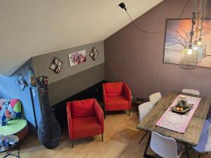 a dining room with a table and red chairs at green hill in Bad Kleinkirchheim