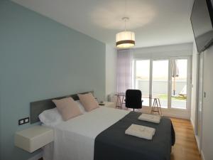 a bedroom with a large white bed and a table at GRAN BILBAO I in Barakaldo