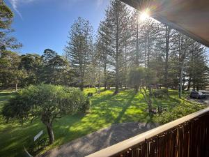 a balcony with a view of a park with trees at Parkview 1- Black Head NSW in Hallidays Point