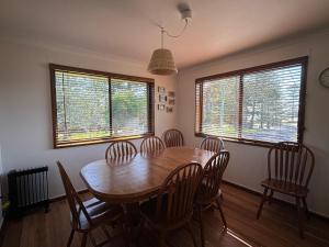 a dining room with a wooden table and chairs at Parkview 1- Black Head NSW in Hallidays Point