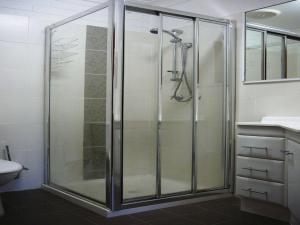 a shower with a glass door in a bathroom at Parkview 1- Black Head NSW in Hallidays Point +11 photos