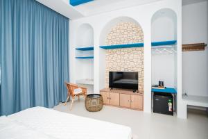 a bedroom with a bed and a tv in a room at Sichon sunrise beach villa in Ban Plai Thon