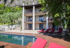 a house with red chairs and a swimming pool at Casa Sopino 3 in Limone sul Garda