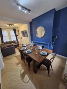 a dining room with a table and a blue wall at 4br House Popular Ravenhill Road in Belfast