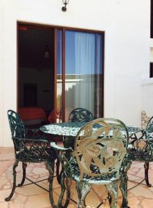 a patio table and chairs with a table and glass doors at Hotel Mariazel in Bernal