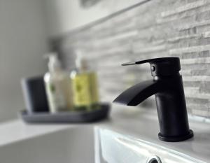 a black faucet on top of a kitchen sink at The Penthouse NY Loft Apartment in Barmouth