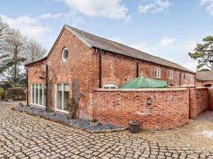 ein Backsteingebäude mit einem grünen Regenschirm drauf in der Unterkunft 3 Bed in Whitchurch 73192 in Whitchurch