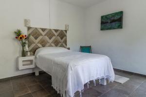 a bedroom with a bed and a vase of flowers at Ecosoul Bugambilia villa in Puerto Vallarta +30 photos
