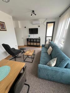 a living room with a blue couch and a table at LiboroApartments in Niš