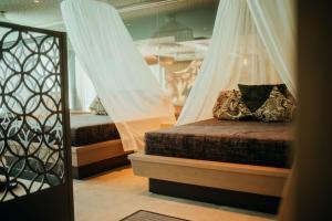a bedroom with two beds with curtains and a mirror at Gartenhotel Moser in Appiano sulla Strada del Vino +35 photos