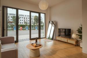 a living room with a tv and a couch and a table at Homestay & Hotel Concept Maison in Quang Tri