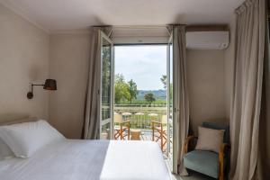 SantʼAndrea in CasaleにあるVilla Yeppaのベッドルーム1室(ベッド1台付)、景色を望むバルコニーが備わります。