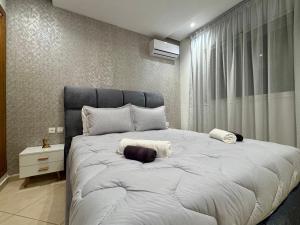 a large white bed in a bedroom with a window at Comfort & Style Apartment in Kenitra