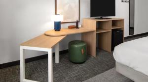a bedroom with a desk and a bed and a desk with a monitor at Spark by Hilton Indianapolis Northeast Fishers in Fishers