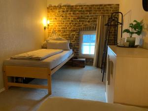 GangeltにあるFerienwohnung Hoffmannのレンガの壁の小さな客室で、ベッド1台が備わります。
