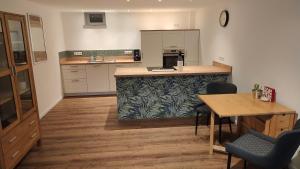 a kitchen with a counter and a table with chairs at Einliegerwohnung 350m vom See in Westensee