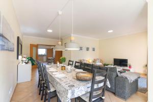 ein Esszimmer mit einem langen Tisch und Stühlen in der Unterkunft Jardins Vale de Santa Maria G, with pool in Albufeira