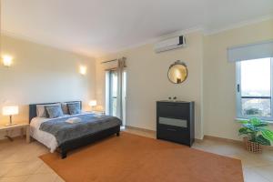 ein Schlafzimmer mit Bett, Schreibtisch und Fenster in der Unterkunft Jardins Vale de Santa Maria G, with pool in Albufeira + 17 Fotos
