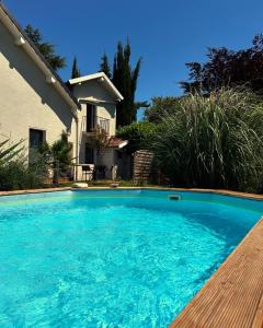 a large blue swimming pool in front of a house at La cigale et la fourmi savoisienne - chambre chez l habitant in Aix-les-Bains