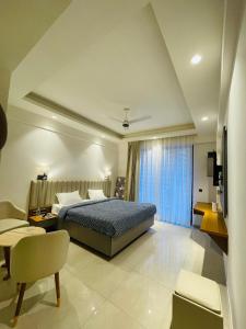 Un dormitorio con una cama, un sofá y un televisor. en Regal stay, en Lucknow