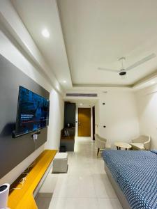 Un dormitorio con una cama y un televisor en una pared. en Regal stay, en Lucknow 10 fotos más