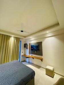 Un dormitorio con una cama y un televisor en la pared. en Regal stay, en Lucknow
