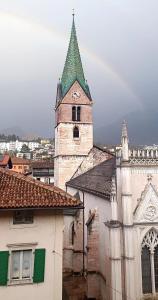 an old building with a tower with a green roof at Dom City Apartments in Trento