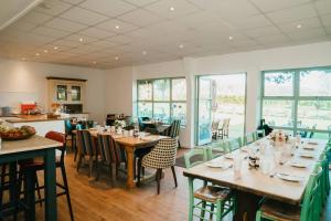 a dining room with tables and chairs and windows at Old Selden Farm B&B in Worthing