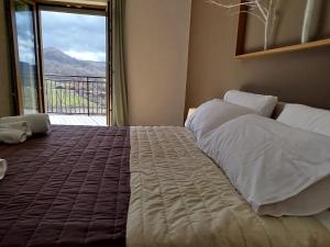 a bedroom with a large bed with a large window at B&B Bosco Ralle - comfort e natura in Satriano di Lucania