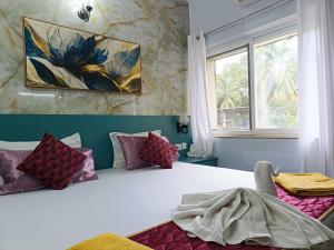 ein Schlafzimmer mit einem Bett und einem Gemälde an der Wand in der Unterkunft Heritage Exotica 2BHK Apartment service apartments in goa in Arpora + 18 Fotos