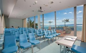 a room with blue chairs and tables and windows at Radisson Blu Resort & Spa in Split