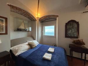 a bedroom with a blue bed with two towels on it at NAPOLEONE vintage house in Imperia