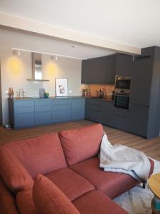 a living room with a red couch in a kitchen at Lofoten Seaview Apartment B in Sennesvik